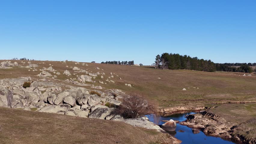 Drone shot of a river flowing through granite rocks in Uralla, New South Wales.