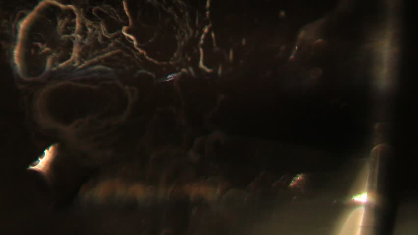 A series of macrovideo demonstrating the physics of light in an uneven black glass with scratches, water stains, and fingerprints, showing the refraction of light in glass and water droplets, chromatic aberration and dispersion, and lens flare.
