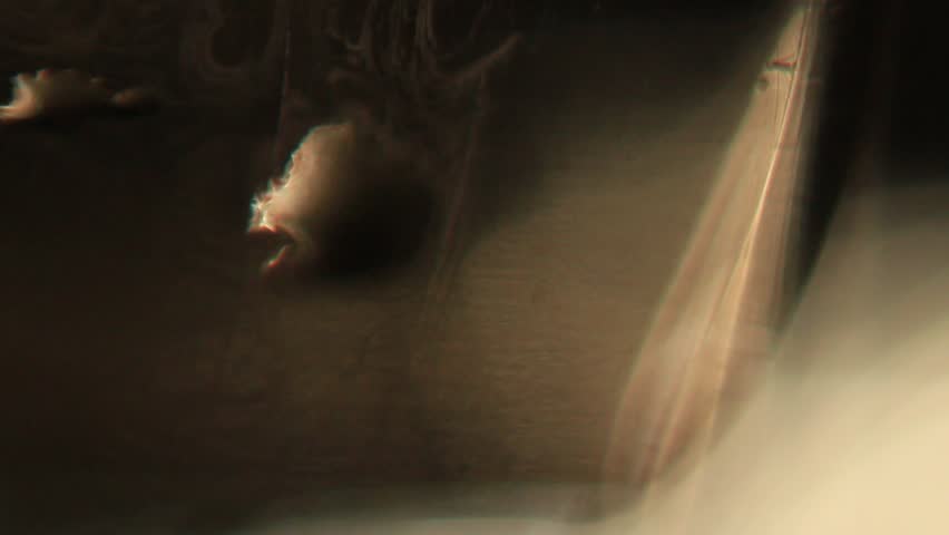 A series of macrovideo demonstrating the physics of light in an uneven black glass with scratches, water stains, and fingerprints, showing the refraction of light in glass and water droplets, chromatic aberration and dispersion, and lens flare.