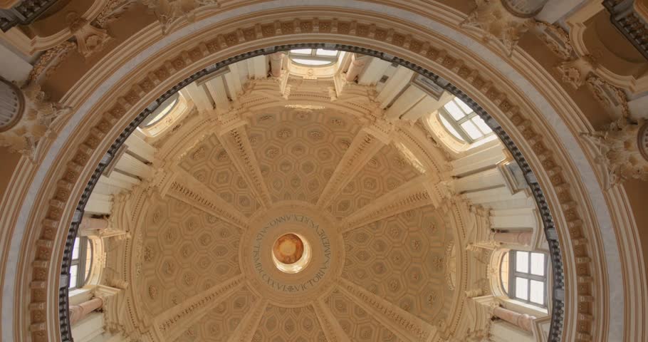 Ornate dome ceiling of Superga Basilica in Turin, Italy framed by bright windows in a static upward view.
