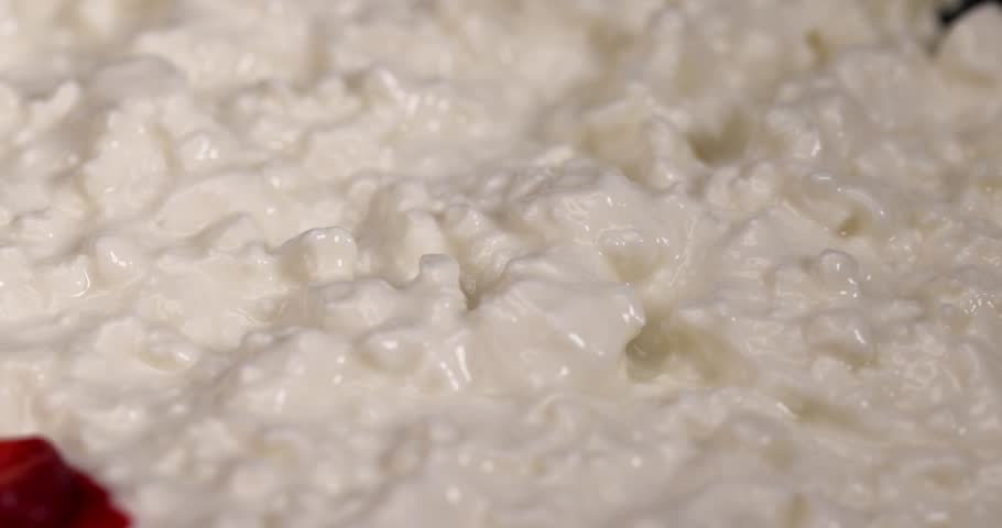 cottage cheese with sour cream and red strawberries, white sour-milk cottage cheese with ripe sweet strawberries cut into pieces