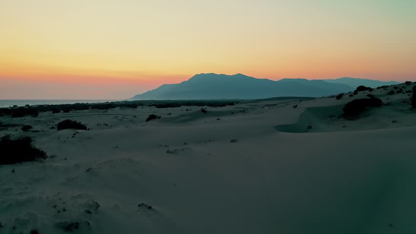 Patara sand dunes sunset aerial view capturing the dramatic golden hour light over the vast desert-like landscape in Antalya, Turkey. Majestic drone shot of coastal dunes.