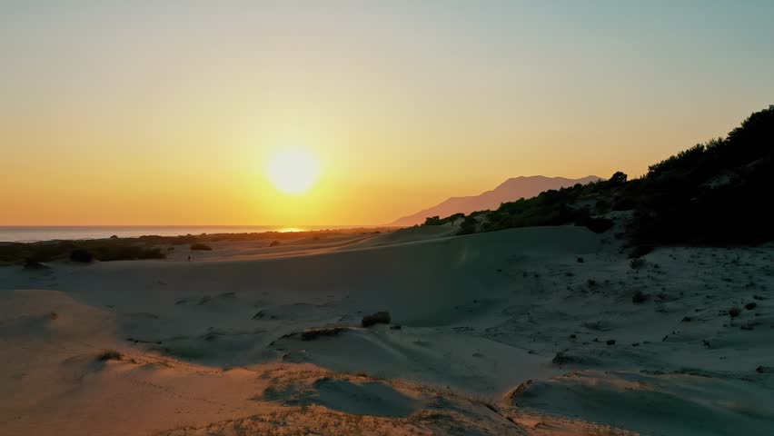 Patara sand dunes sunset aerial view capturing the dramatic golden hour light over the vast desert-like landscape in Antalya, Turkey. Majestic drone shot of coastal dunes.