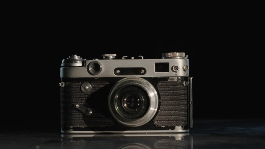 Retro vintage film analog photo camera on black background close-up