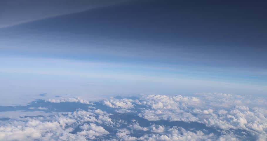 Flying view above clouds and mountains.