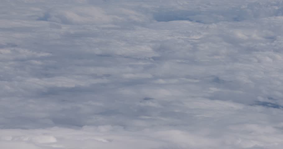 Flying view above clouds and mountains.