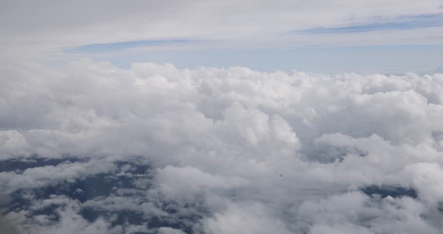 Flying view above clouds and mountains.