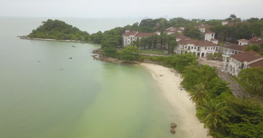Aerial drone view of luxury resorts building by calm island beach scenery at Pulau Besar, Malaysia