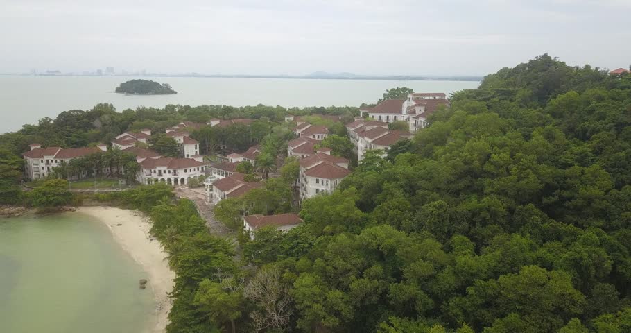 Aerial drone view of luxury resorts building by calm island beach scenery at Pulau Besar, Malaysia