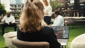 Businesswoman uses trading chart with financial data on laptop screen, typing market indicators for analytics. - Powered by Shutterstock - Get 15% off with code: PIKWIZARD15