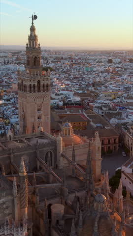 Vertical Aerial glimpse of Seville at sunset. Golden hour illuminates historic Seville city and architecture. Spaine