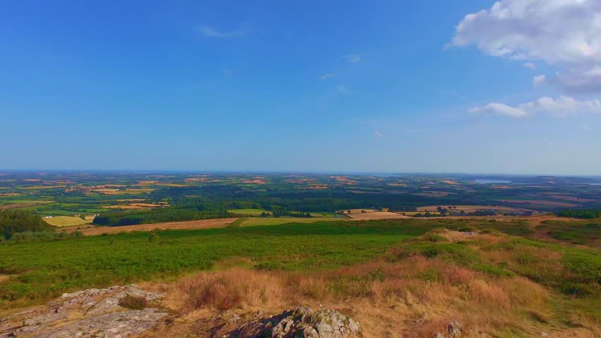 Panoramic view over green fields from high hill lookout