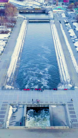 Vertical video. Ekaterinburg, Russia. City center. Iset River, Walking area. Early spring. Sunset time. Aerial View. Rich colors