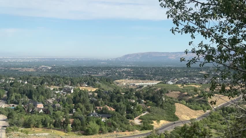 A broad overlook of the Salt Lake Valley, with foothills and neighborhoods in the foreground and the city spread out toward distant mountains.