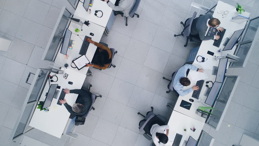 Aerial Top Down Drone Shot of Big Busy Corporate Office with Tow Rows off Businessmen and Businesswomen Working on Desktop Computers. Open Space Office with Businesspeople and Salespeople
