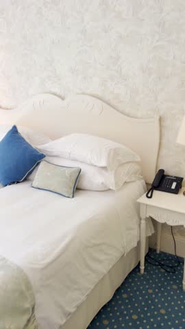 POV from phone camera on luxury hotel room or suite with twin bed desk and lamps. Enjoying tourist resort or business trip. User generated content UGC of travel vlogger in vertical social video reel
