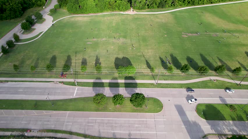Aerial footage from a far distance of people playing cricket in Frisco Texas