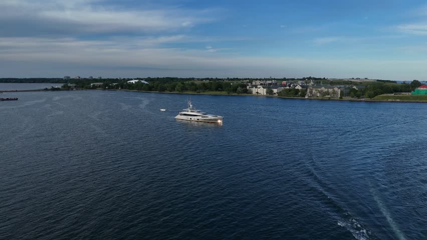 Luxury superyacht "Bella Vita" cruising through Kingston Harbour on Lake Ontario, Canada. Aerial waterline footage captures the sleek vessel.