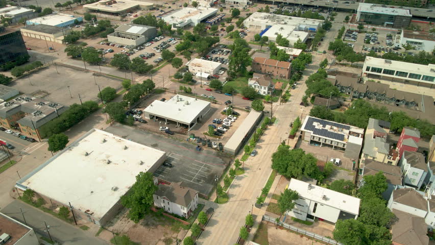 Aerial drone shot revealing the Downtown Houston skyline with a smooth upward camera tilt, showcasing modern skyscrapers and office towers beneath dramatic clouds during daytime in Houston, Texas, USA