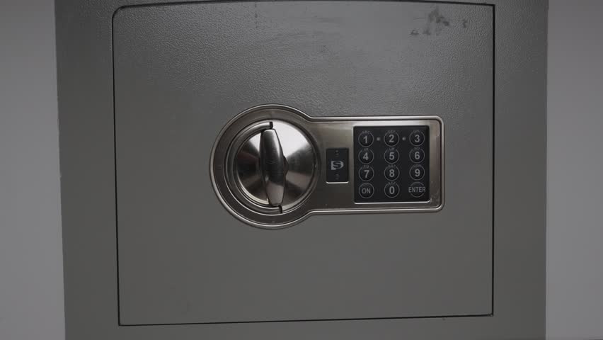Male hand pulling thick bundle of hundred dollar bills out of open metal safe box. Close up on cash savings retrieval, banking transaction and wealth accumulation.