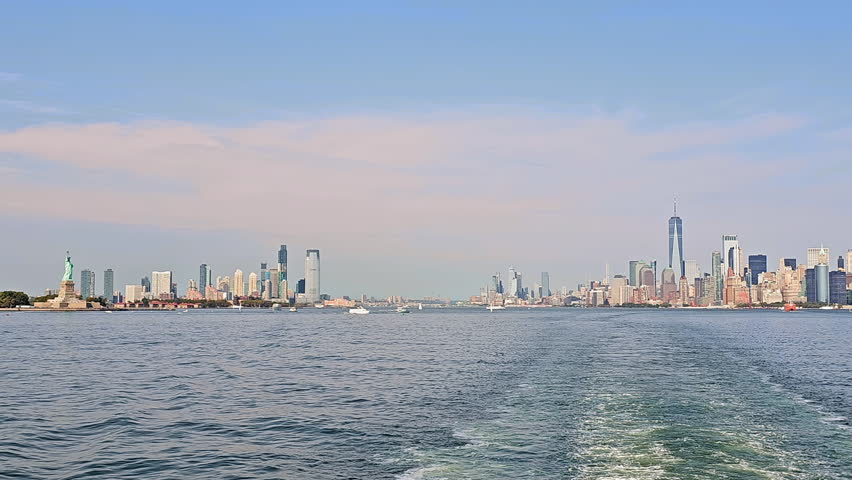 New York Harbor skyline with Statue of Liberty and Lower Manhattan, Boat view shows Jersey City towers and One World Trade Center across water