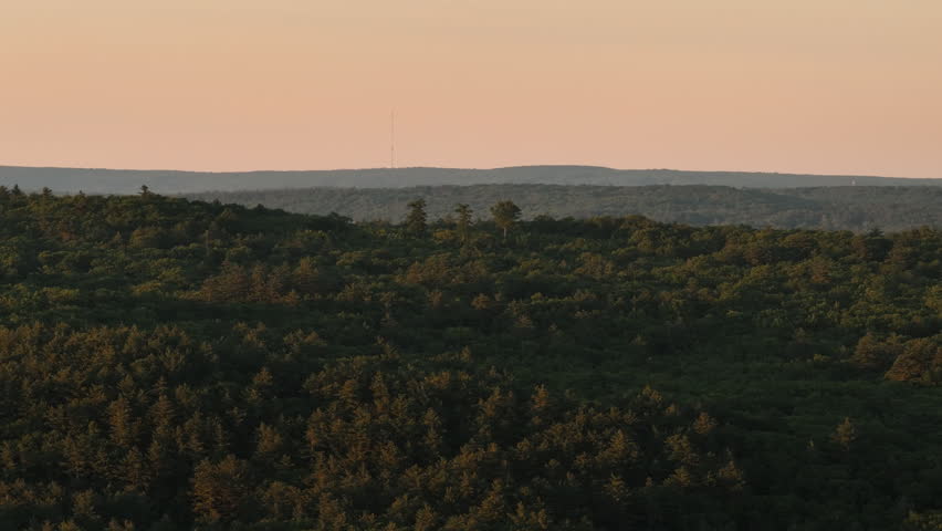 Aerial view of rolling hills and forest in rural Connecticut. Shot at sunset during the summer,