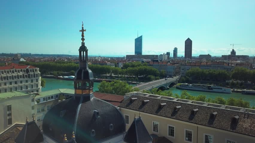 A City skyline view over river with domed rooftop and modern towers in Lyon, France