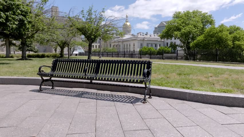 New Jersey state capitol building in Trenton, New Jersey with bench and drone video moving up.