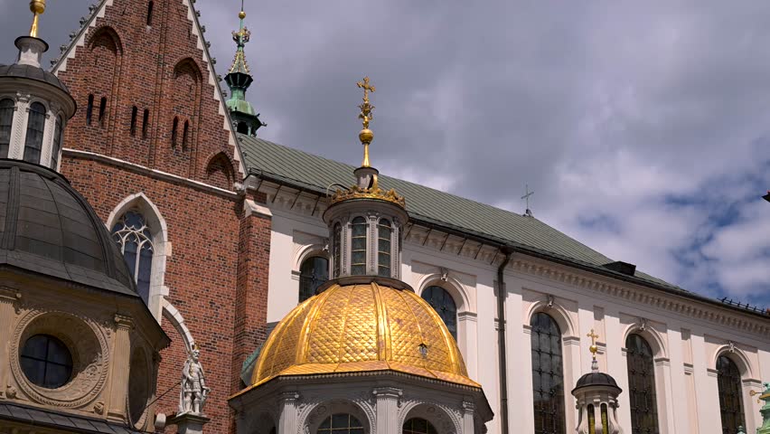 Sigismund Chapel’s gilded dome and ornate facades sit below a moving sky in this slow upward shot.
