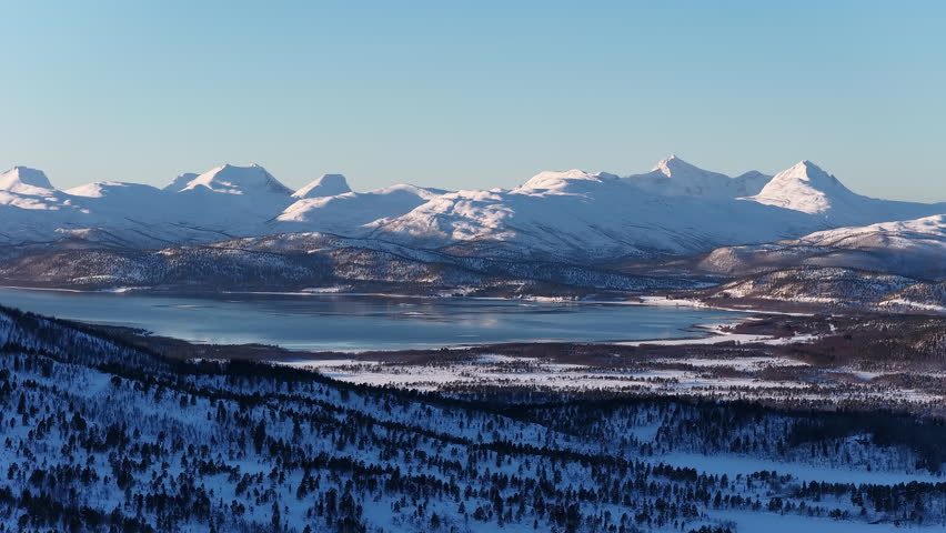 Aerial view of snowy mountain range and frozen lake, Norway