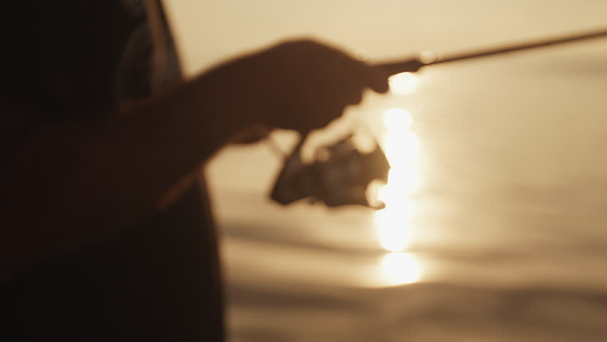 Angler stands in the boat and fishing on the lake