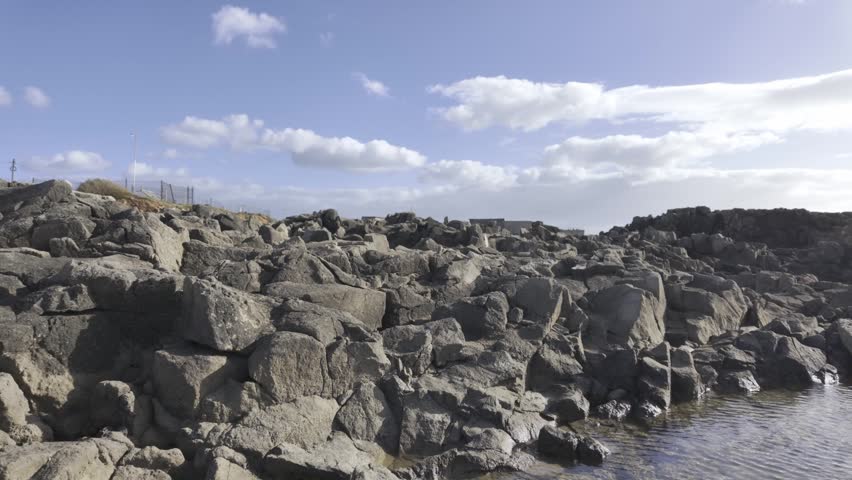 A rugged coastal view with rocky shoreline and open sea at Cabo Raso in Cascais, Portugal