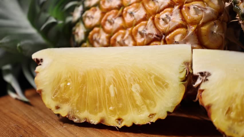 Juicy Pineapple Slices on Wooden Table with Black Background	