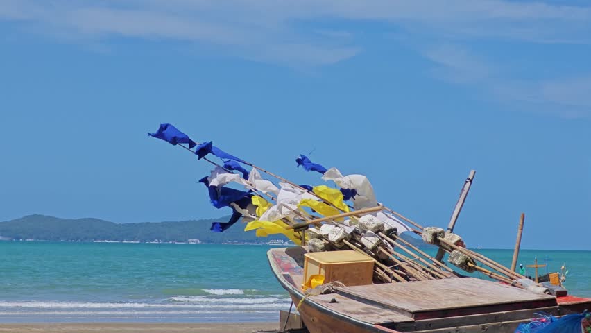 Boat on the beach with flag warning sign.