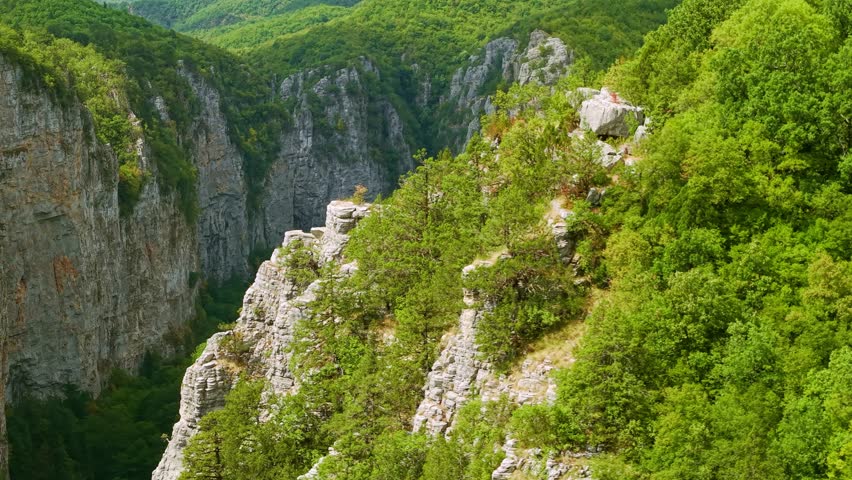 Aerial view of the massive limestone cliffs and deep canyon floor of the Vikos Gorge in the Zagori region, Greece