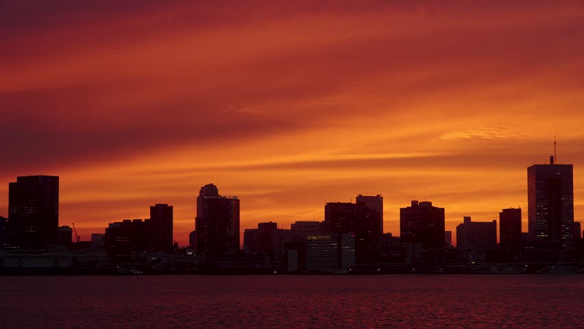 Beautiful sunset over Tokyo Bay viewed from Shinagawa Pier in Tokyo, Japan, featuring the city skyline and colorful evening sky.