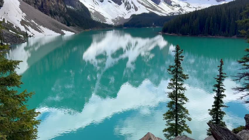 Beautiful view on the Moraine Lake in National Park of Banff, Canada. Stunning view of a mountain lake with turquoise water reflecting surrounding peaks and trees, showcasing the natural beauty.