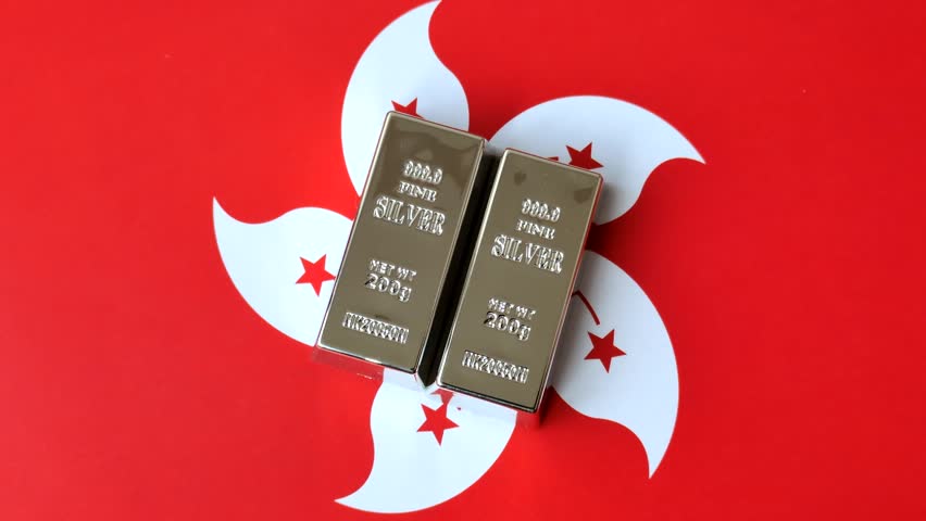 A silver bar, white metal against a backdrop of hong kong flag, as a concept. A silver bar