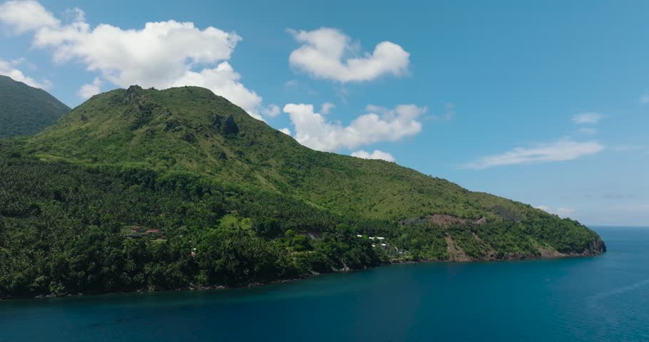 Mountain cliff near the coast. Blue sea in Camiguin Island. Philippines.