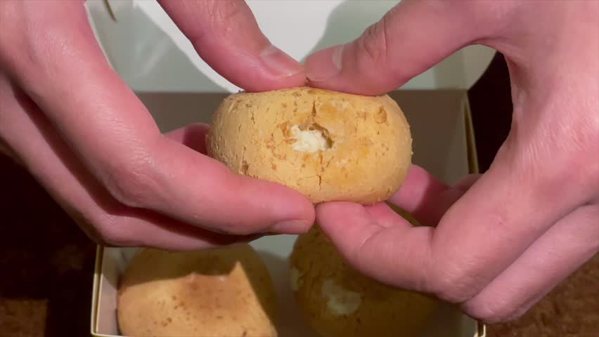 Hand holding creamy durian filled cream puff
