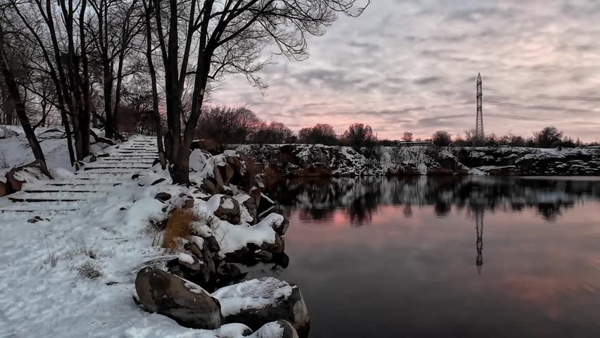Sunset cumulus sky over a lake in winter in city