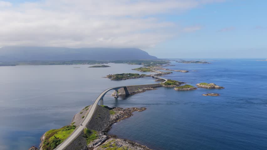 Aerial drone view of the Atlantic Ocean Road in Norway. Winding highway bridge connecting islands across rough ocean waves during a scenic coastal road trip.