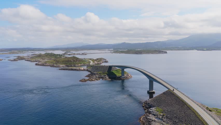 Aerial drone view of the Atlantic Ocean Road in Norway. Winding highway bridge connecting islands across rough ocean waves during a scenic coastal road trip.