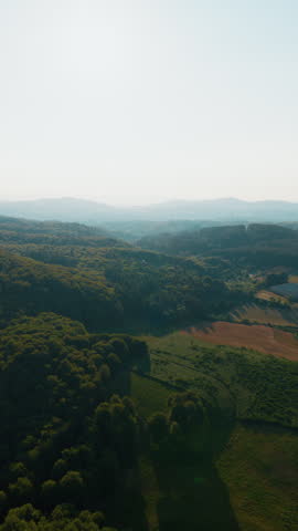 Aerial vertical view of misty hills and farmland