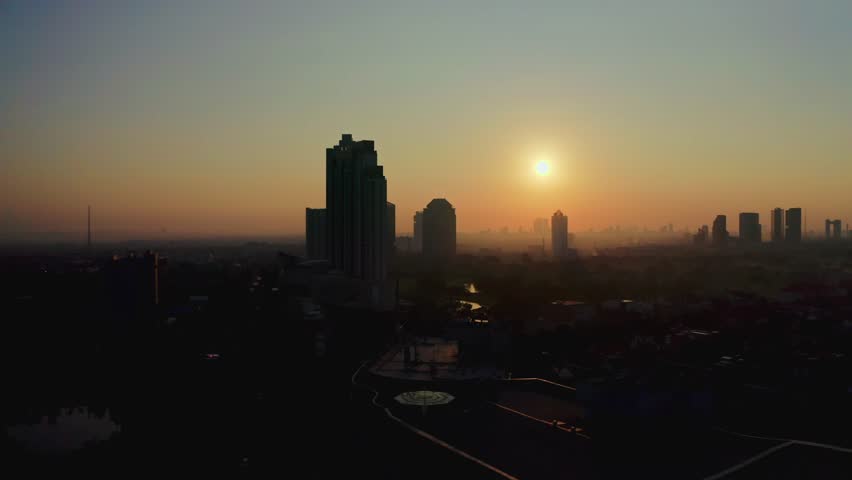 Aerial sunset view of city skyline and urban buildings in Surabaya East Java Indonesia