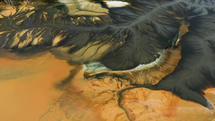 Aerial abstract surreal natural patterns above. Colorful chemical mining leach residues in decanting pond by drone