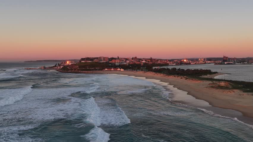 Nobbys sandy beach at Newcastle city in Australia – aerial sunrise zoom in view.