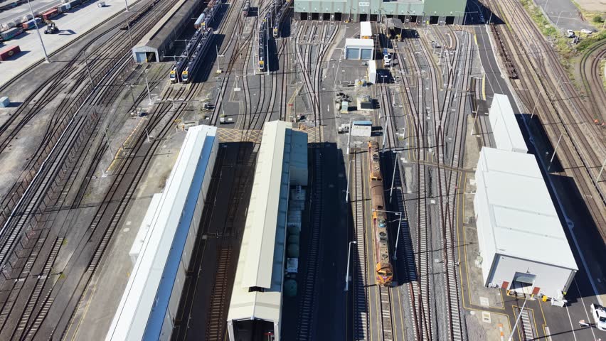 Aerial view of a train moving through a large railway junction with many tracks