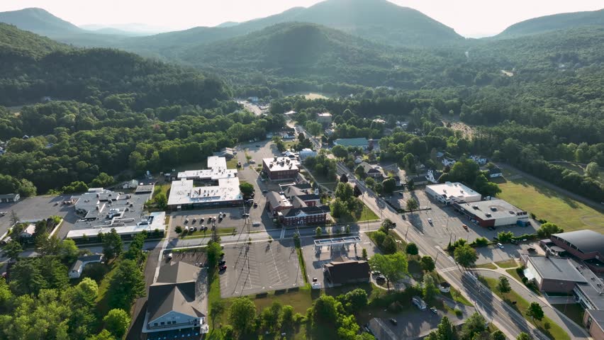 Aerial view of Court Street in Elizabethtown, New York, surrounded by forested Adirondack mountains under clear summer skies.