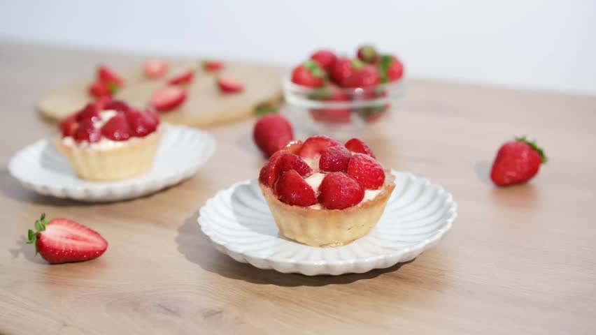 Strawberry tarts are placed on a wooden table